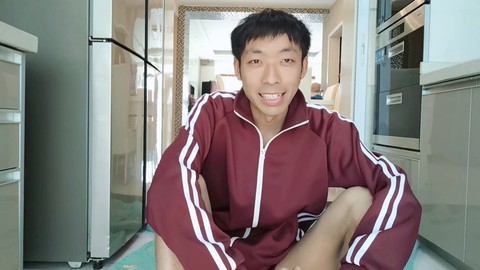 Süßer asiatischer Junge in einer privaten Küche, der sich an einem schönen Nachmittag vergnügt
