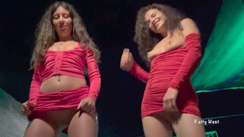 Zwei Schlampen tanzen auf einer öffentlichen Party und zeigen ihre prallen Titten und Ärsche
